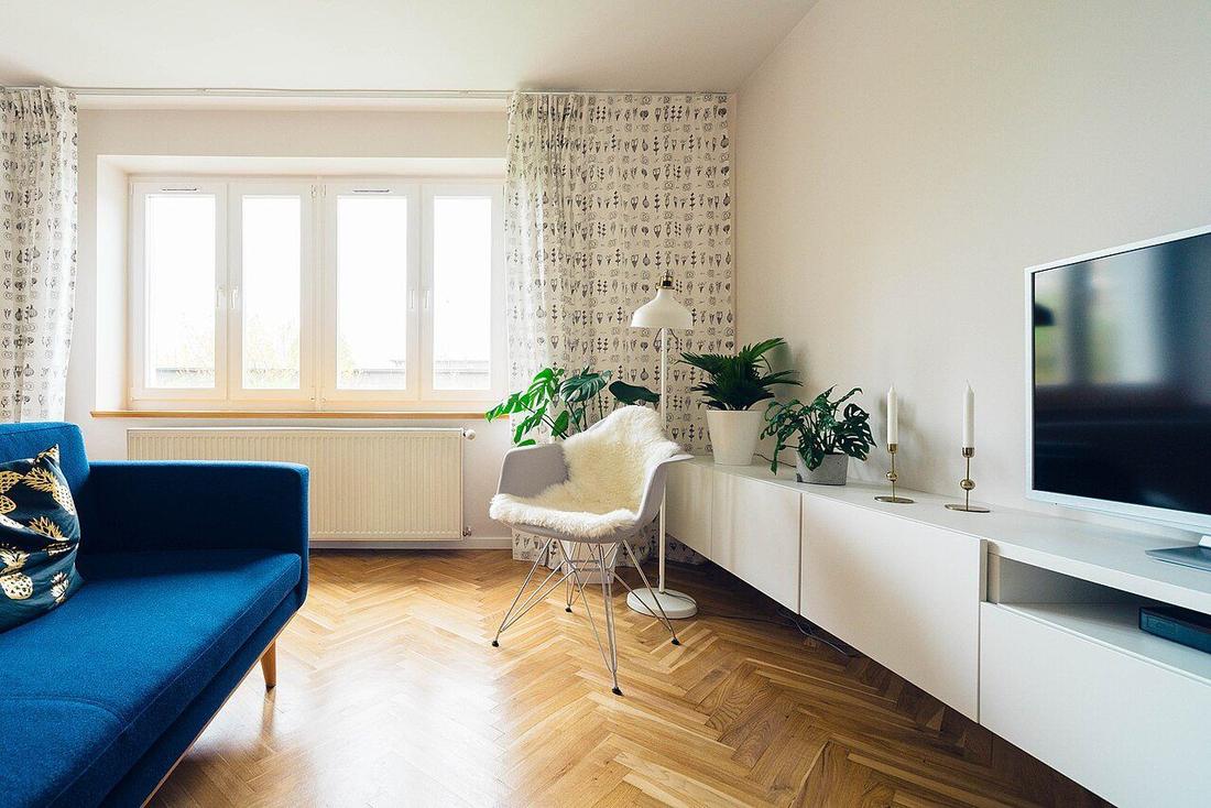 Bright living room with plank flooring: housing quality remains a consumption good, even in the calculation