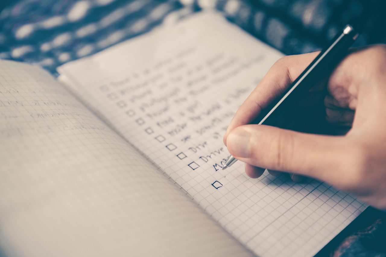 Hand setzt auf einer To-do-Liste ein Häkchen, Symbol für Vorsorgeplanung
