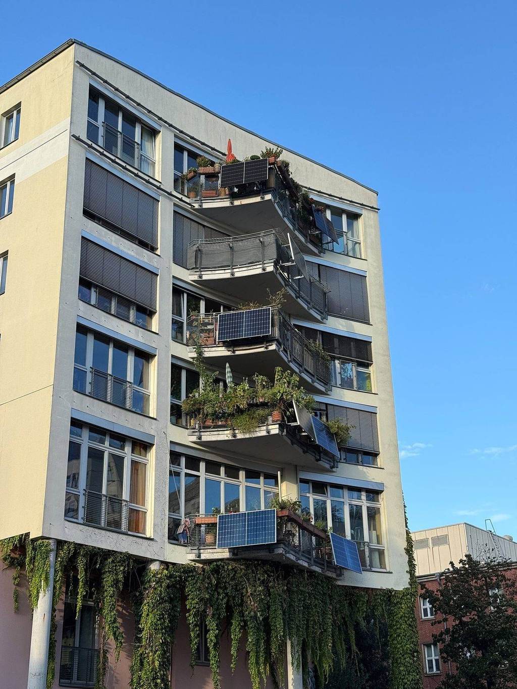 Balkonkraftwerk mit zwei Solarmodulen an einem Balkongeländer eines Mehrfamilienhauses