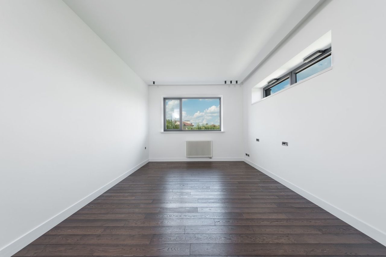Leeres, helles Wohnzimmer einer neuen, noch frisch gestrichenen Wohnung